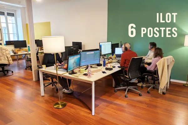 Grand espace de coworking avec 6 postes de travail pour équipes, ambiance professionnelle